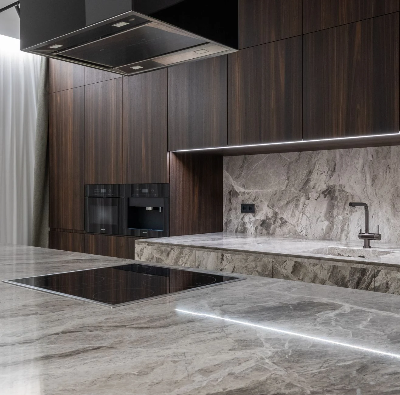 Modern luxury kitchen with natural stone countertops and stone backsplash