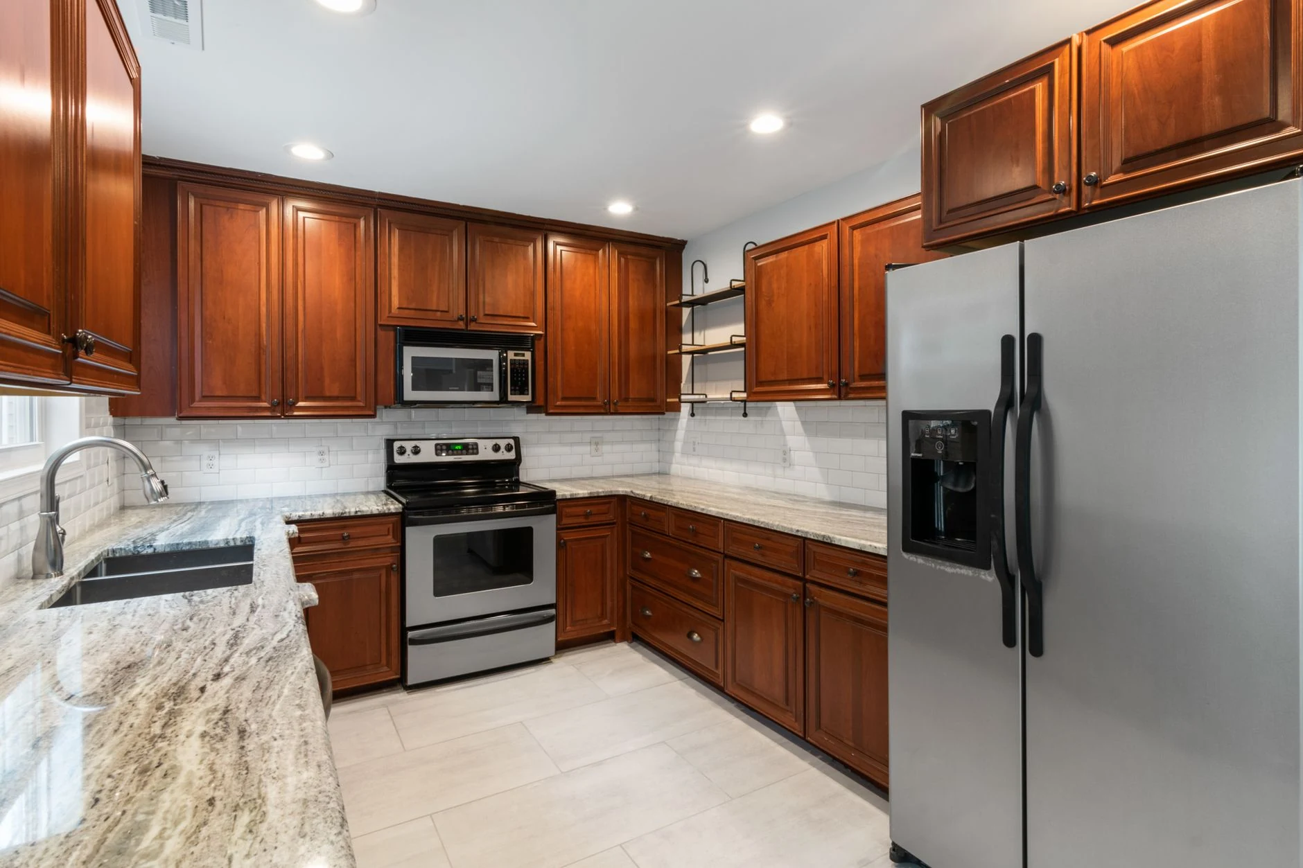 Kitchen with natural stone countertops and warm wooden cabinetry